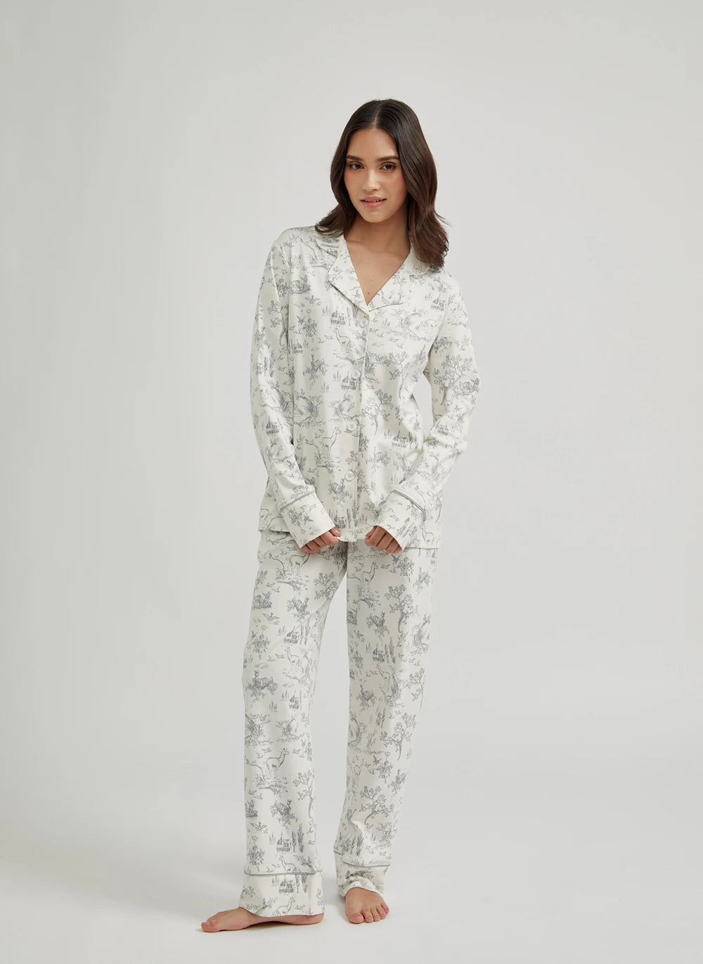Woman wearing a white pima cotton floral pajama set on a plain background