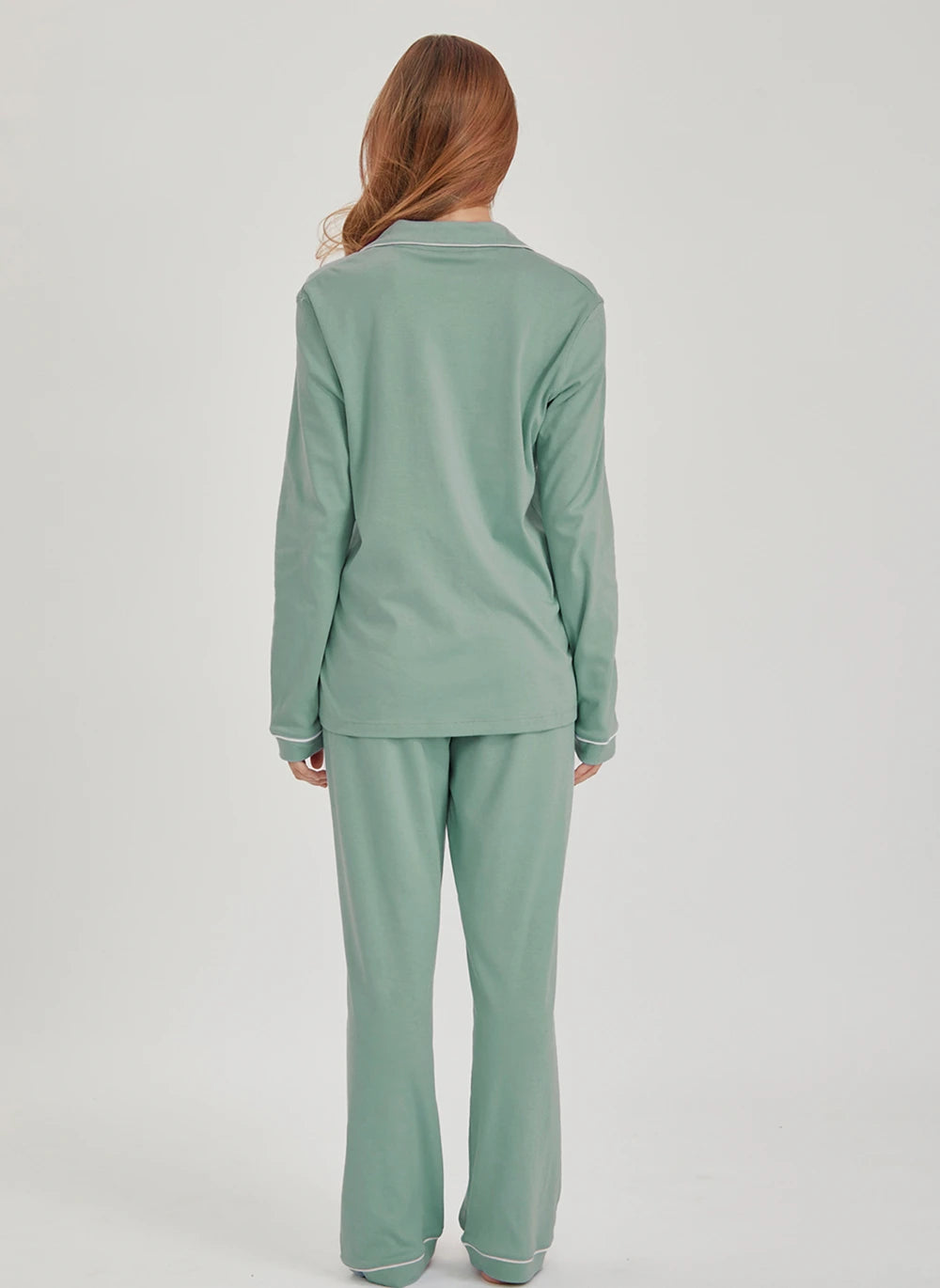 Person wearing a green pima cotton pajama set on a light gray background