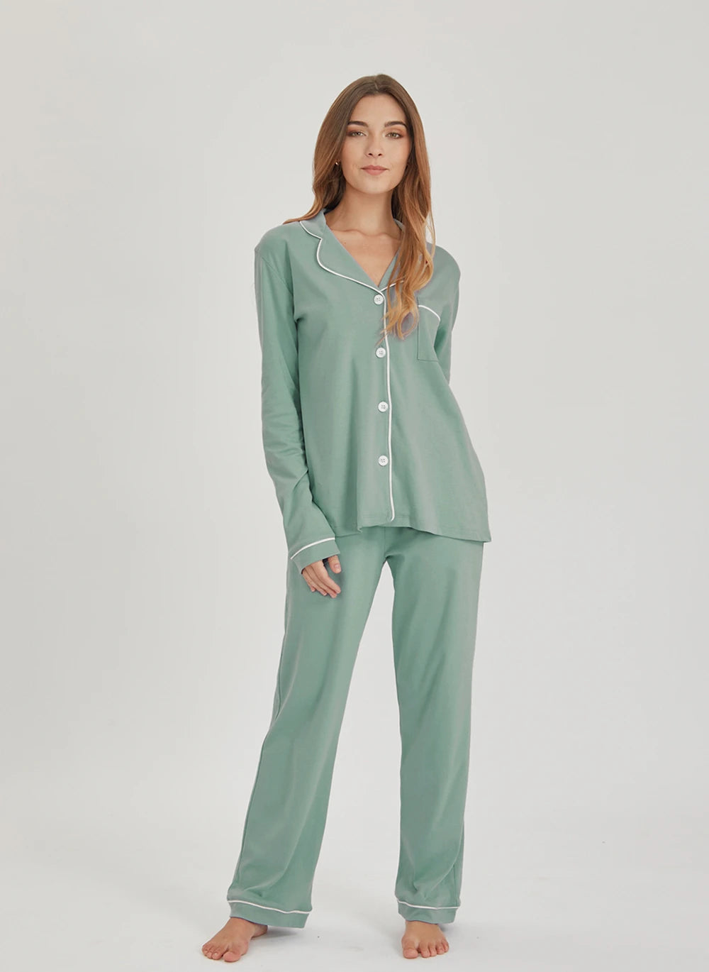 Woman wearing a green pajama set against a white background