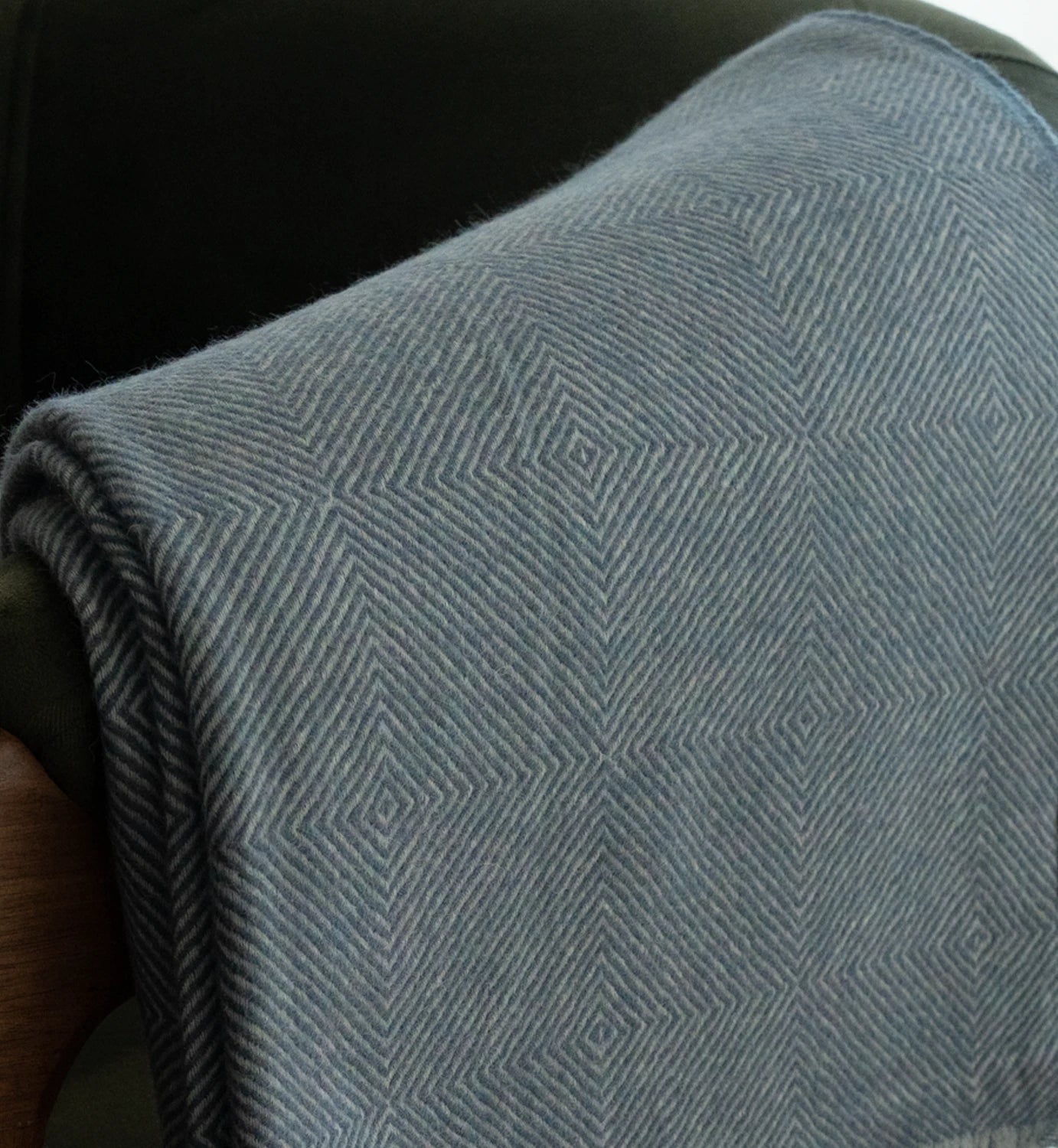 Close-up of a textured blue blanket with a diamond pattern.