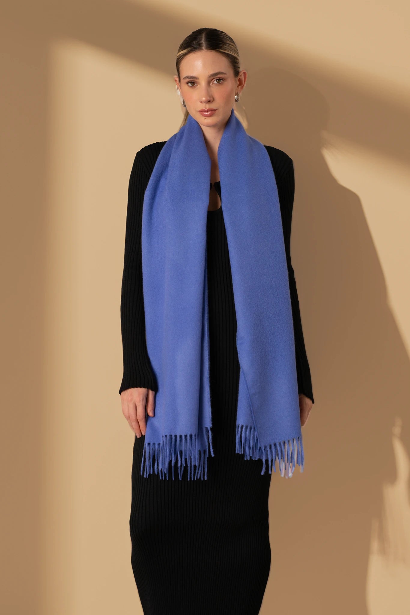 Woman wearing a blue scarf against a beige background