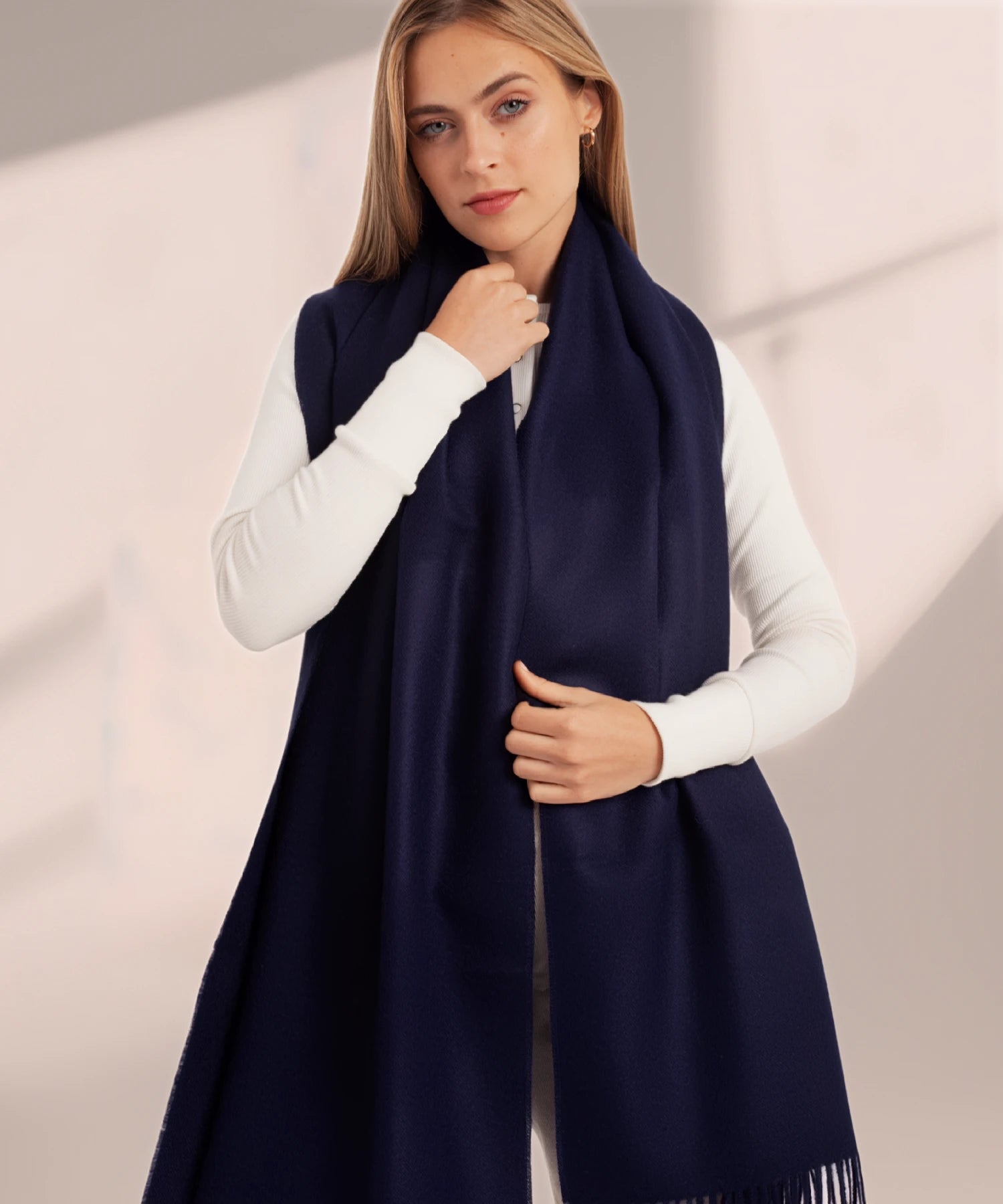 Woman wearing a navy blue scarf against a neutral background