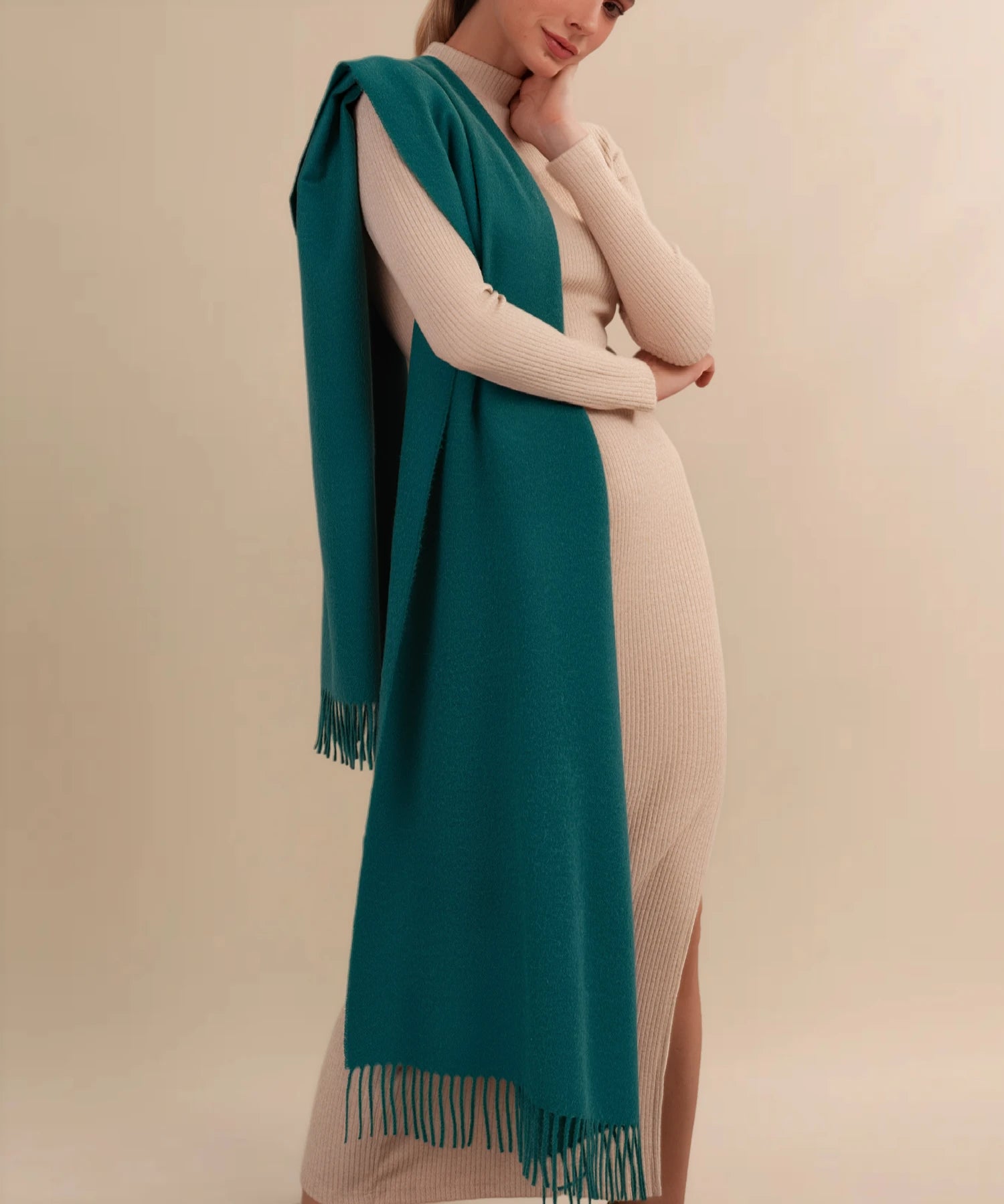 Woman wearing a long teal scarf with a beige background
