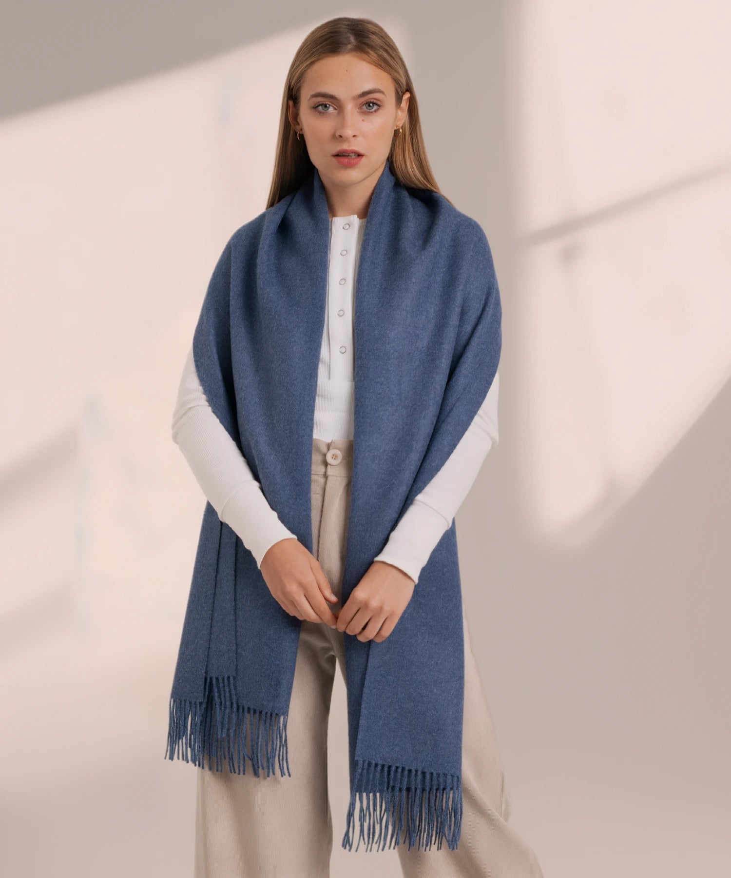 Woman wearing a blue scarf against a neutral background