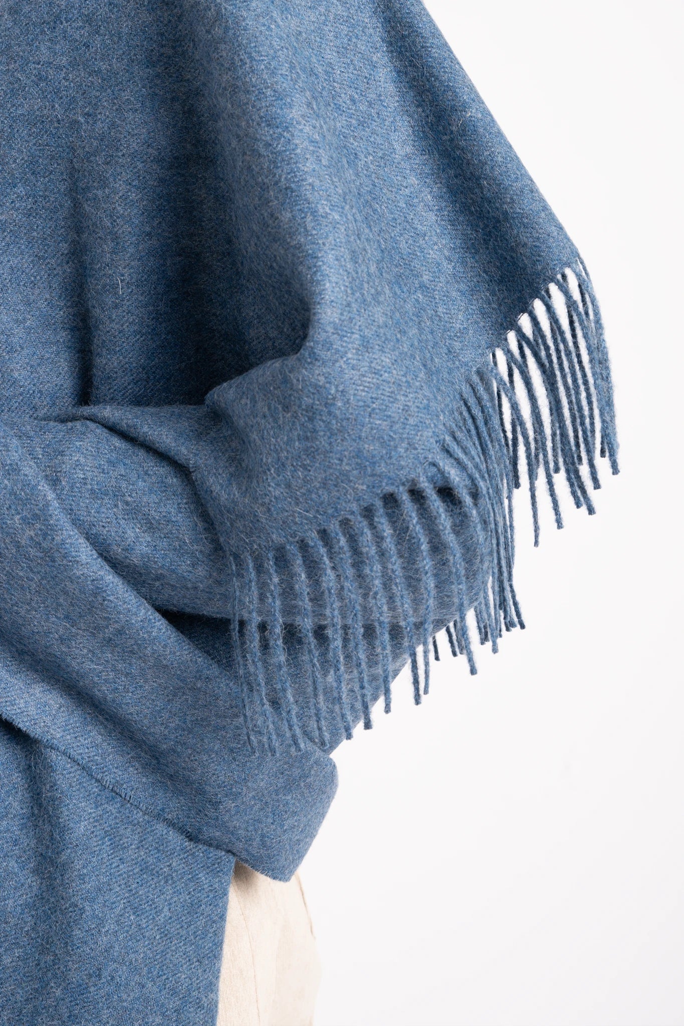Blue fringed sweater on a white background