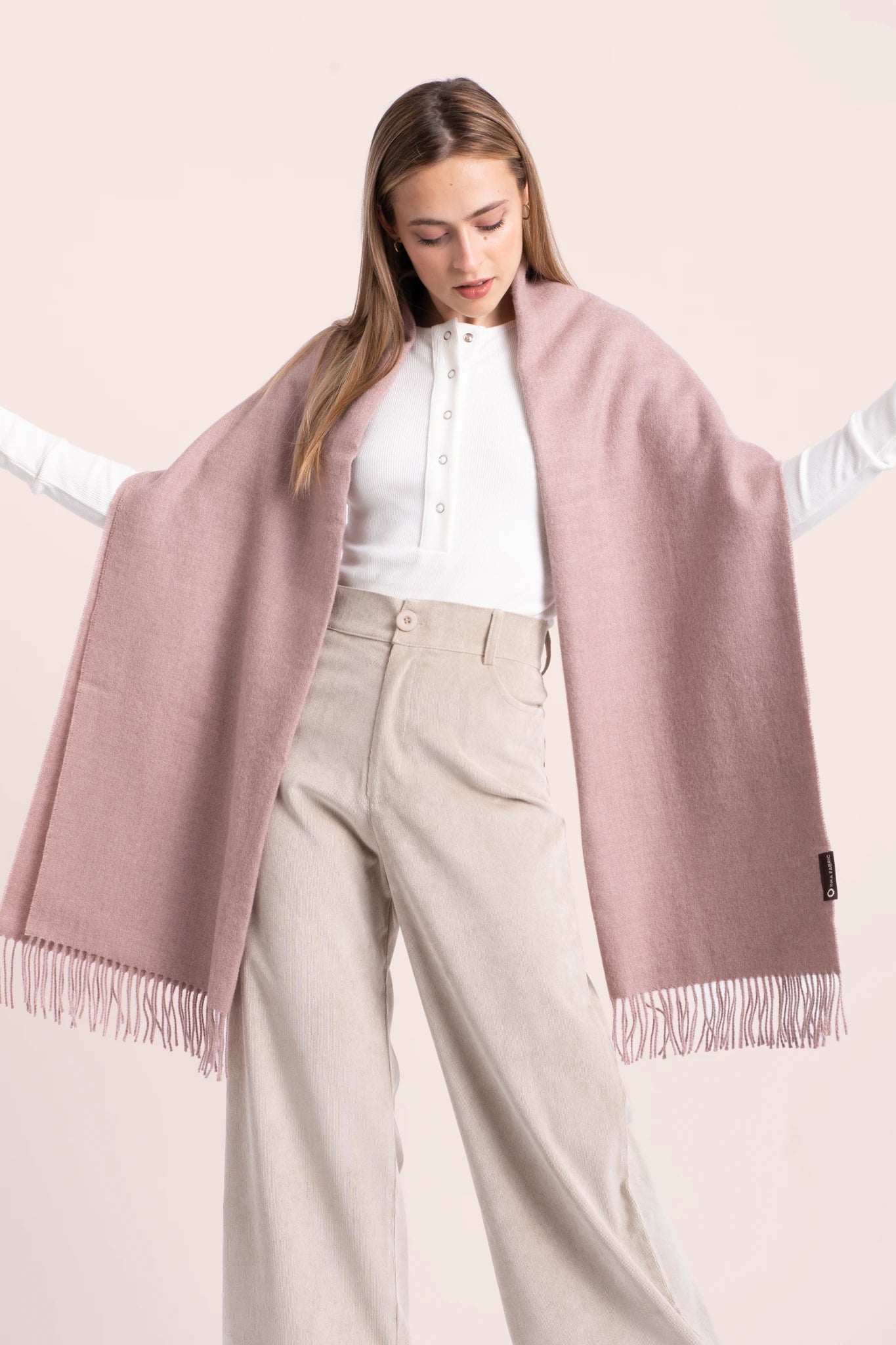 Woman wearing a pink scarf with a plain background