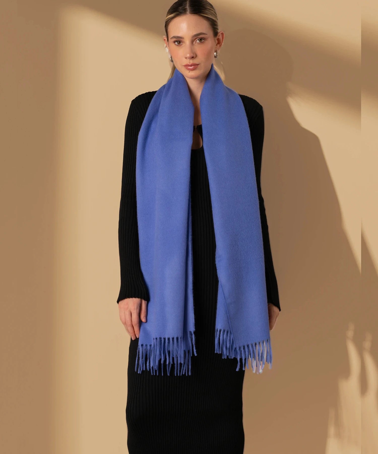 Woman wearing a blue scarf against a beige background