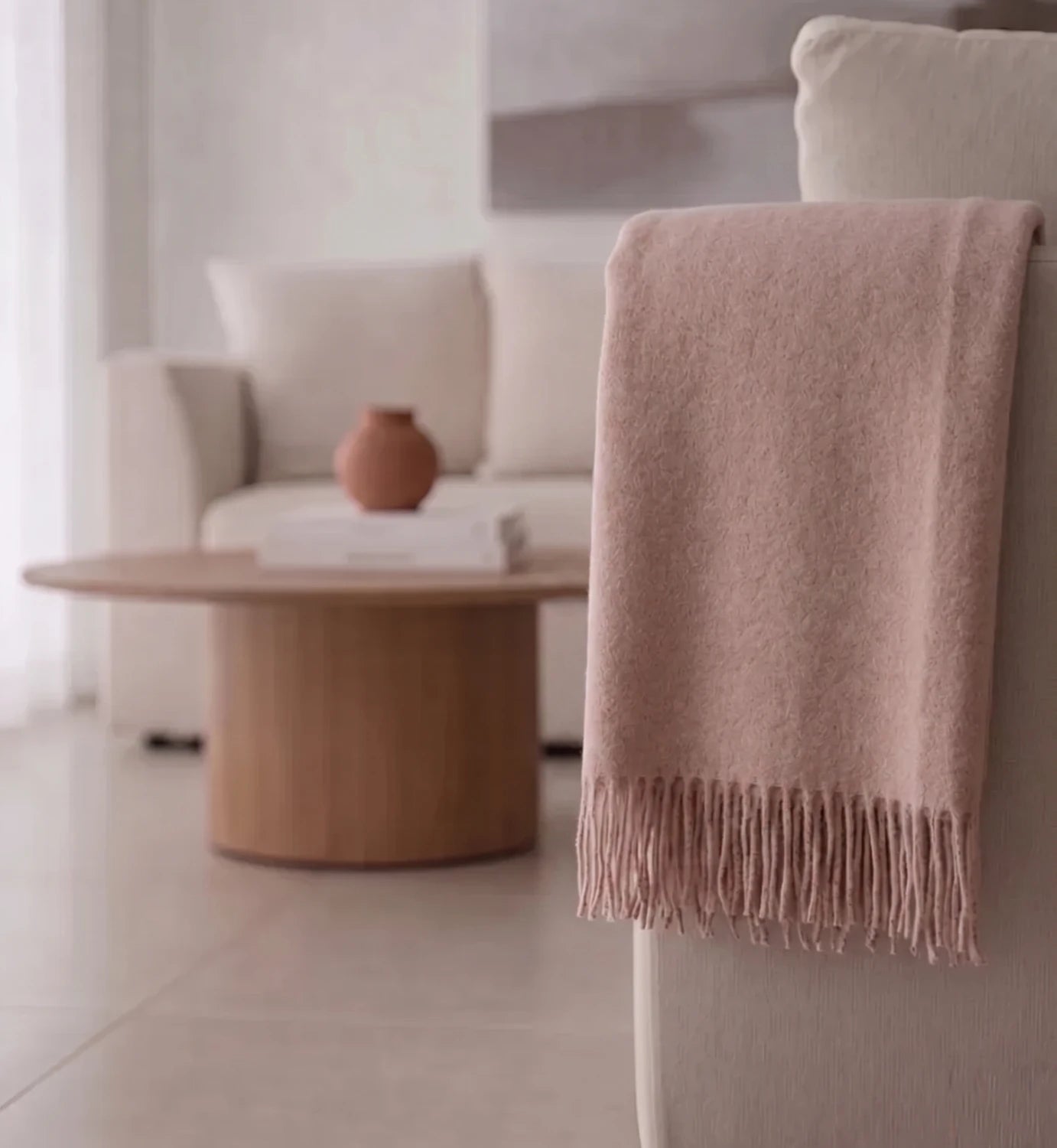 Pink blanket draped over a chair in a modern living room setting.