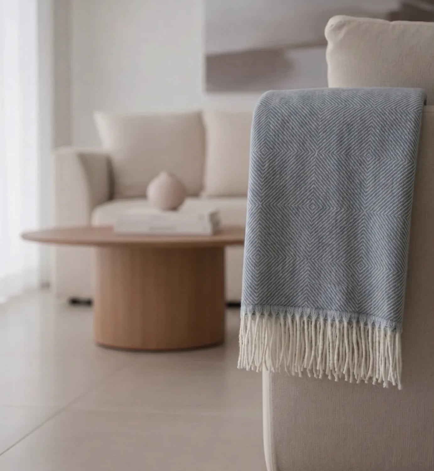 Gray throw blanket draped over a chair in a living room setting.