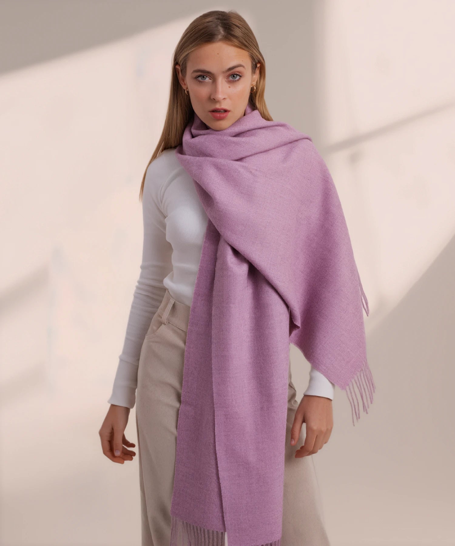 Woman wearing a purple scarf on a plain background