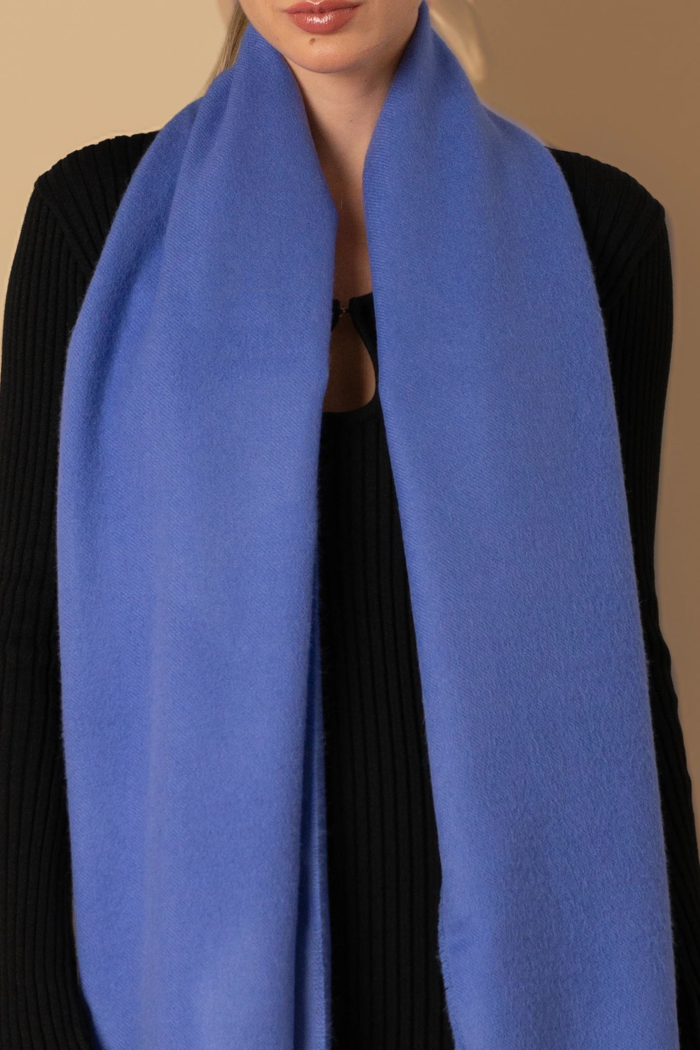 Person wearing a blue scarf with a plain background