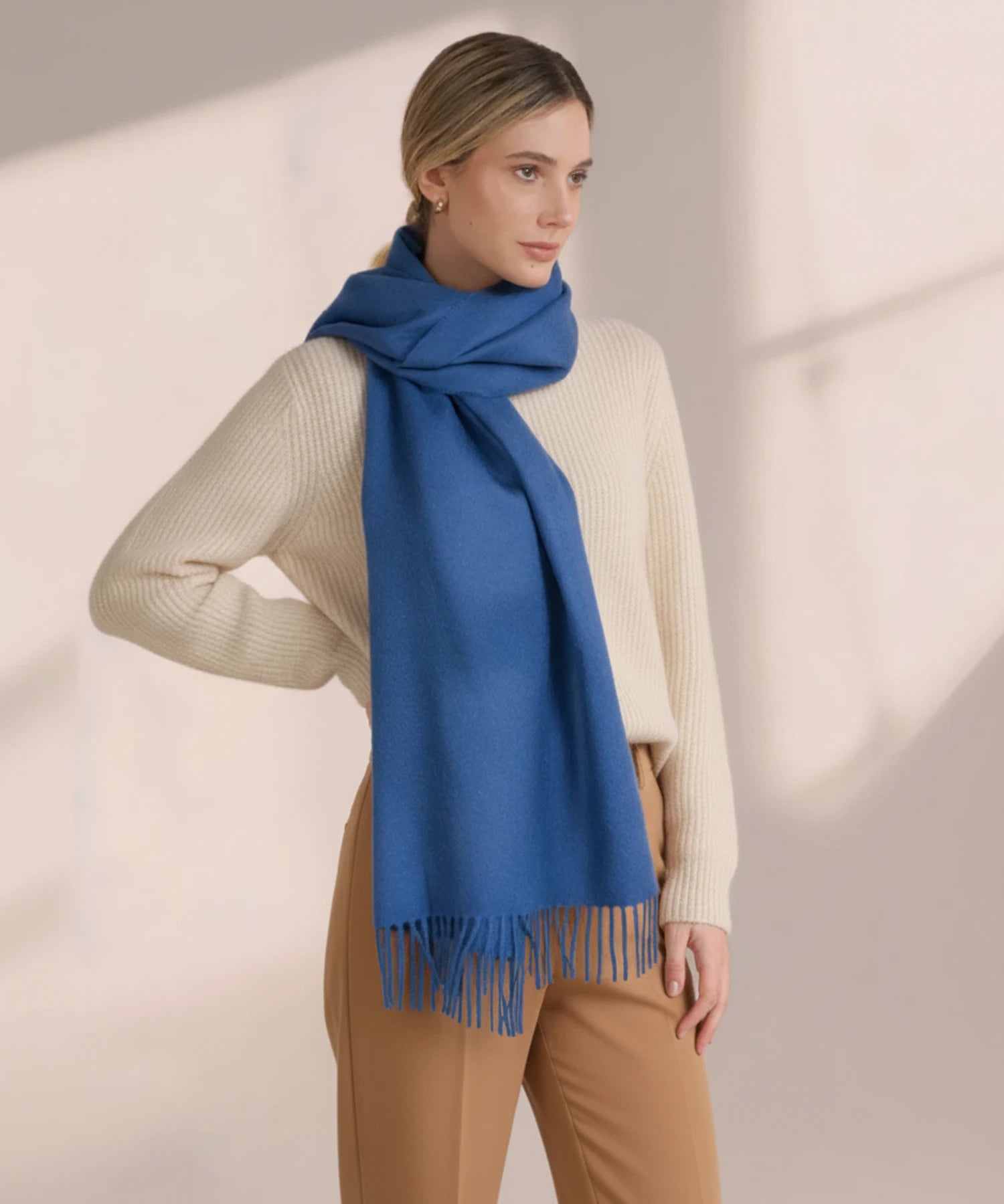 Woman wearing a blue scarf with a beige background