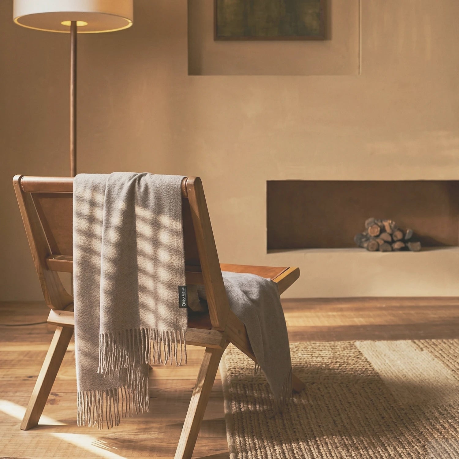 Chair with a blanket draped over it in a cozy room with a fireplace.