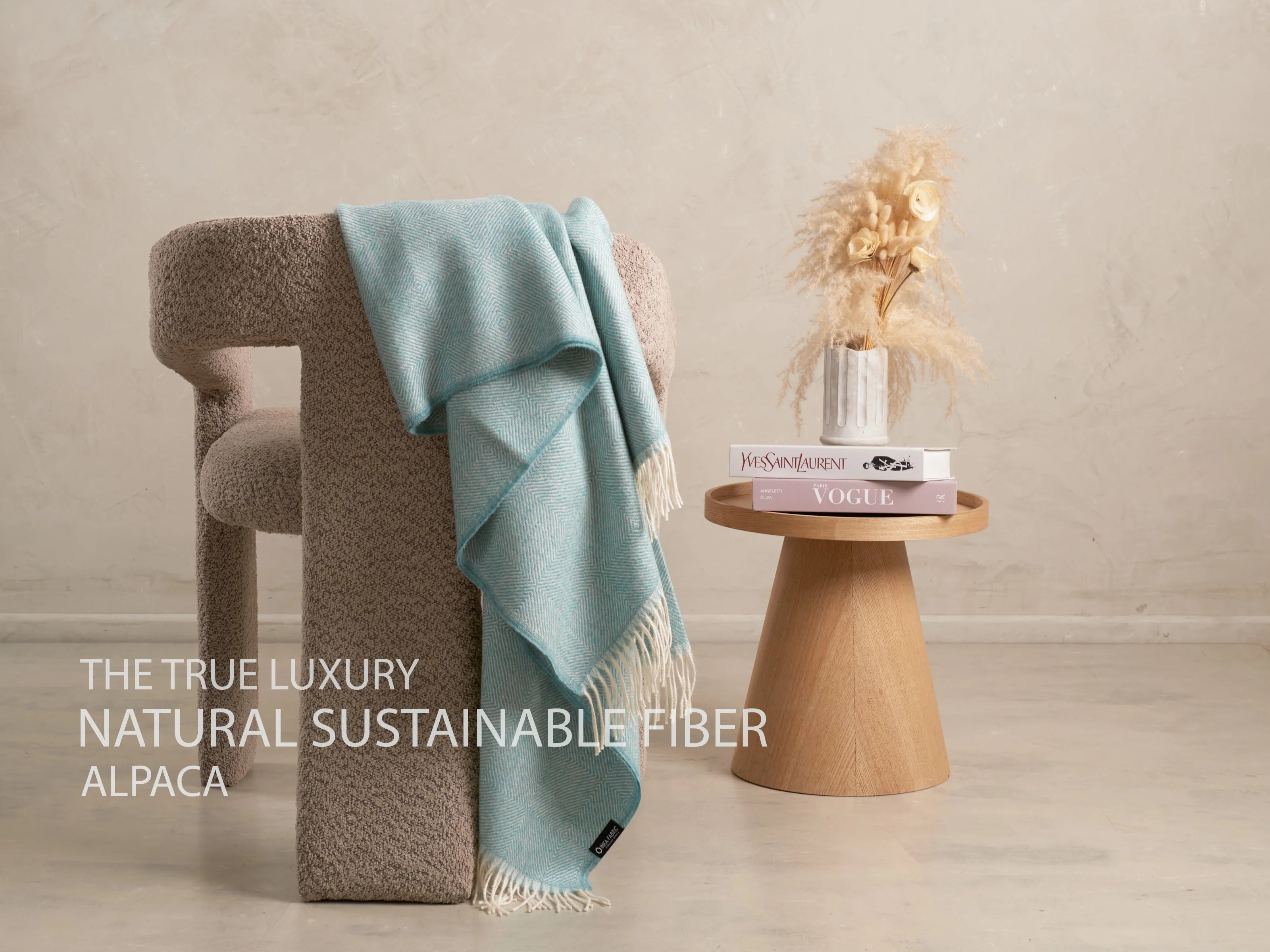 alpaca blanket colour teal show in a grey chair 