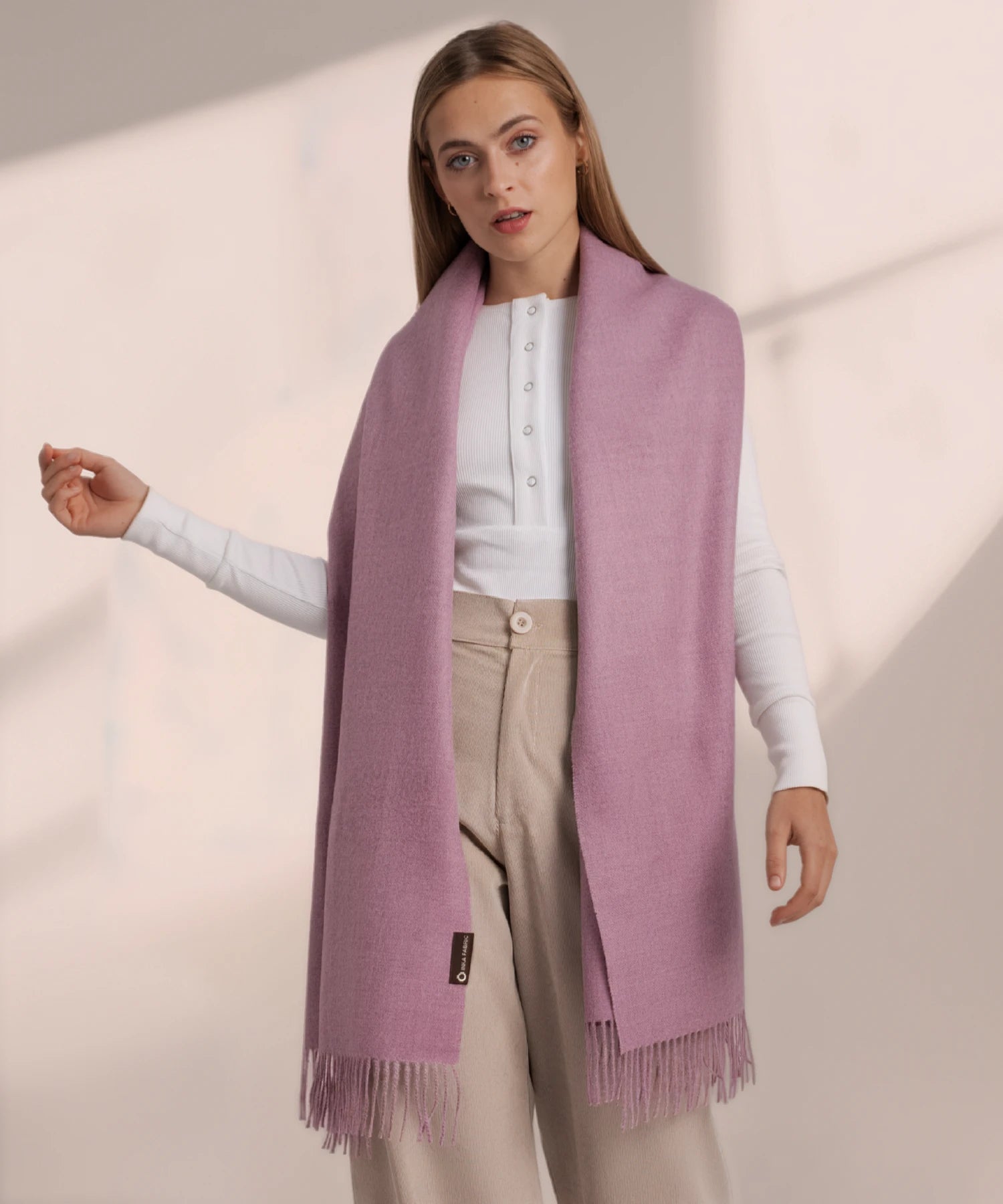 Woman wearing a pink scarf on a plain background