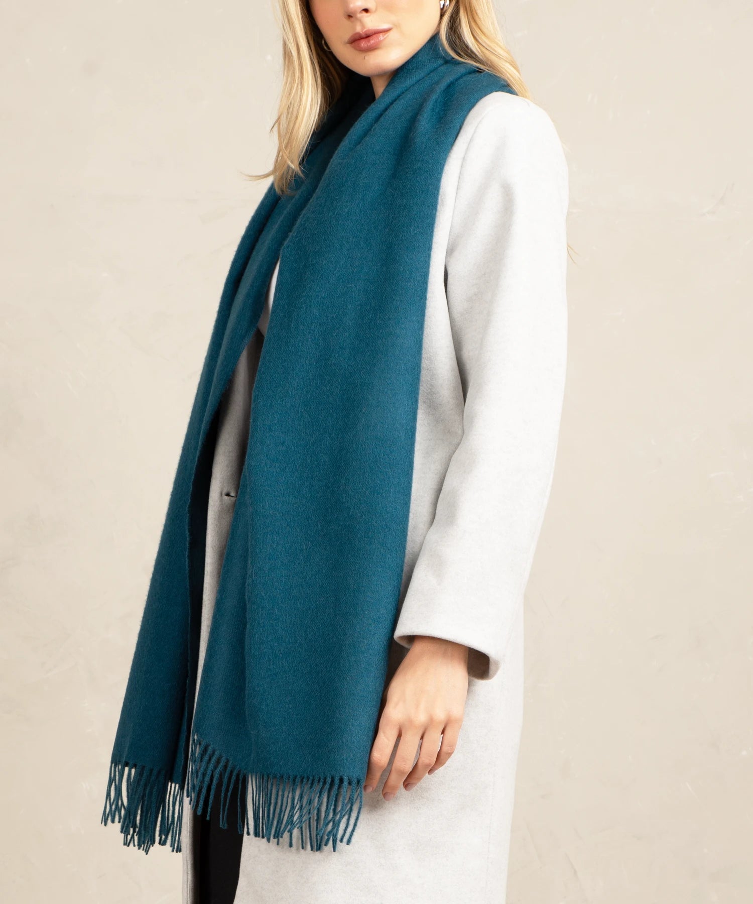 Person wearing a teal scarf with a plain background