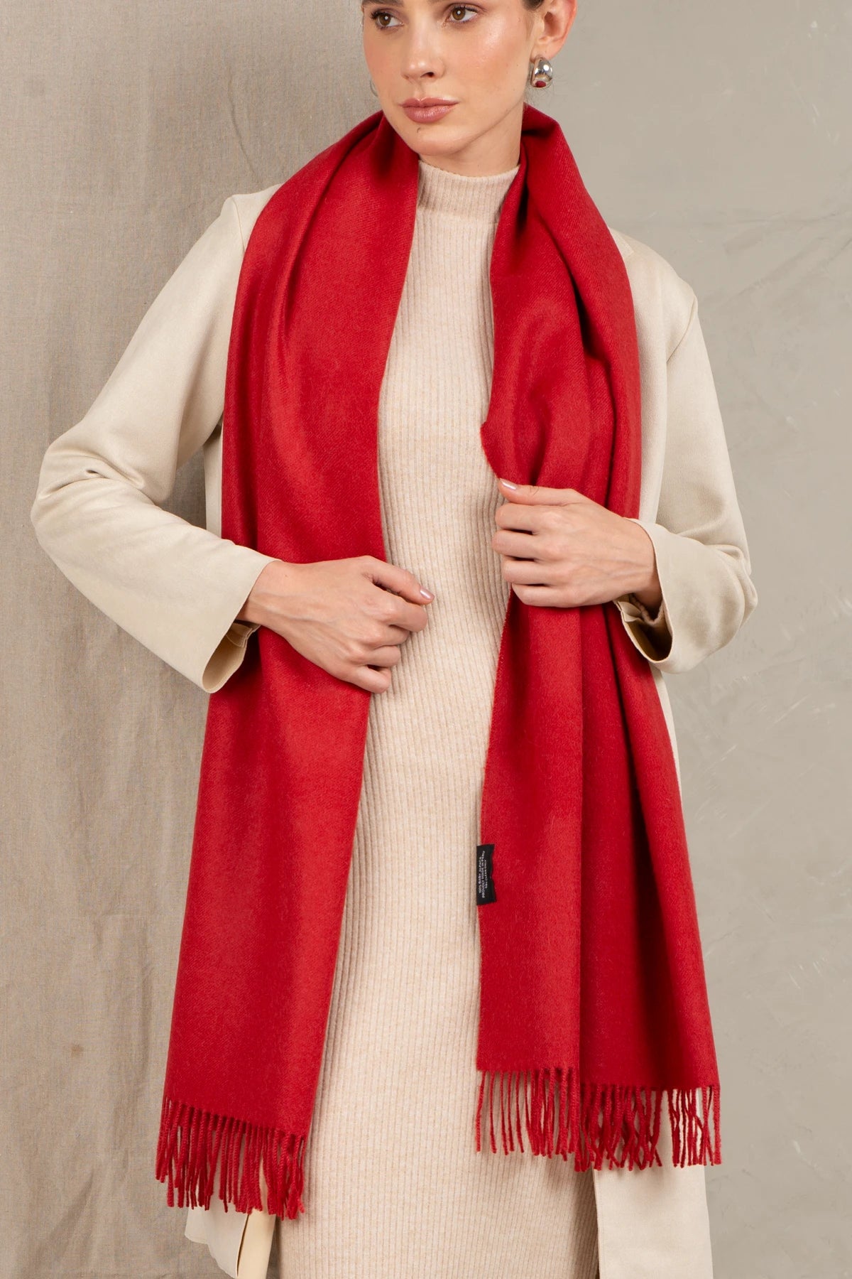 Woman wearing a 100% baby alpaca red scarf with a neutral background
