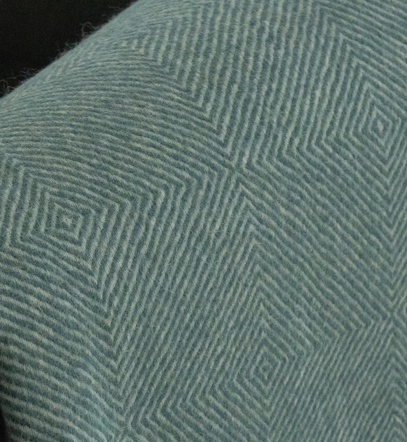 Close-up of a textured green fabric with geometric pattern